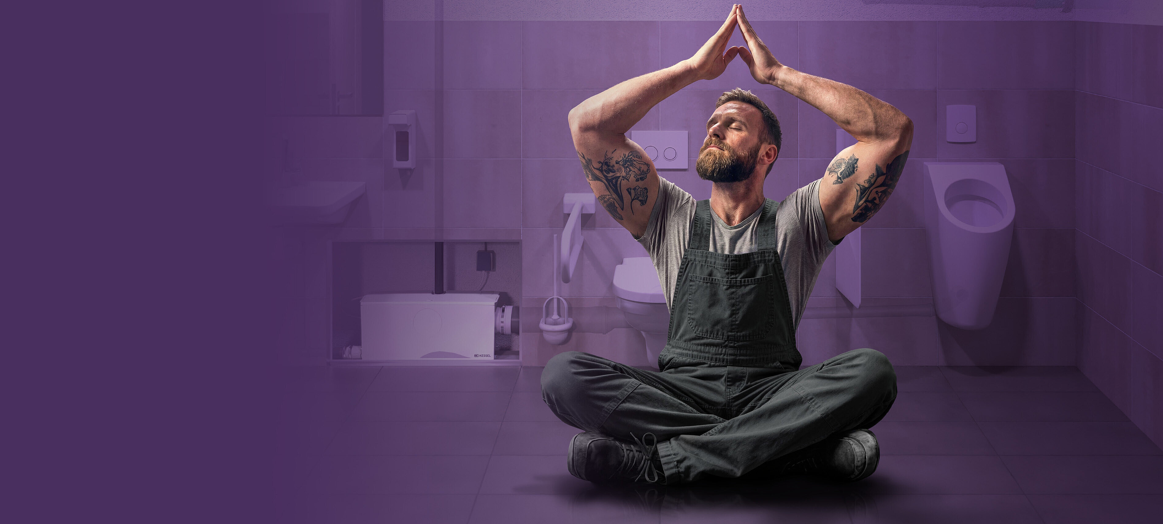 Un artisan détendu dans des toilettes publiques, avec un système de double chasse d'eau en arrière-plan.